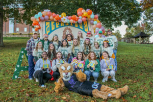 a group of people posing for a photo with a Mountain Lion Mascot